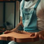 Viral Music - A man in overalls sitting in a chair with a guitar