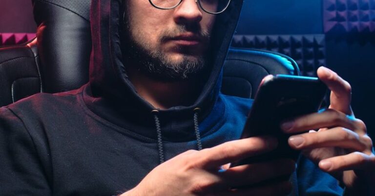 Data Breaches - A Man in Black Hoodie Sweater Using His Mobile Phone