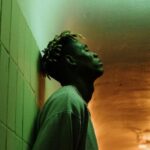 Urban Green Spaces - Man in Gray Dress Shirt Standing Beside White Wall