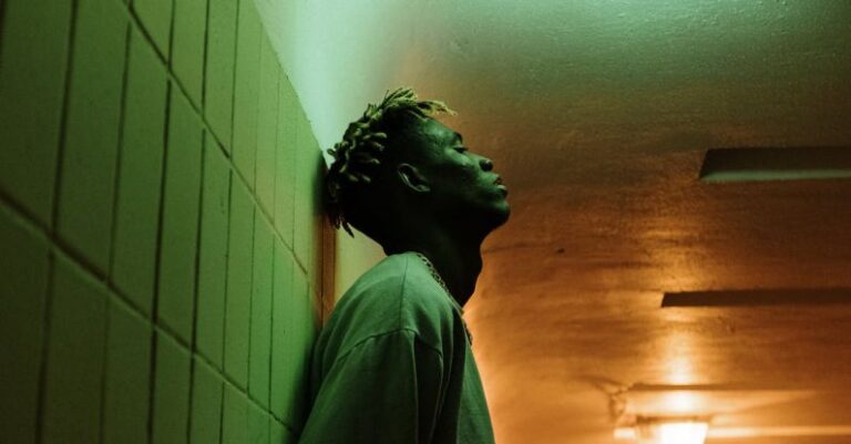 Urban Green Spaces - Man in Gray Dress Shirt Standing Beside White Wall